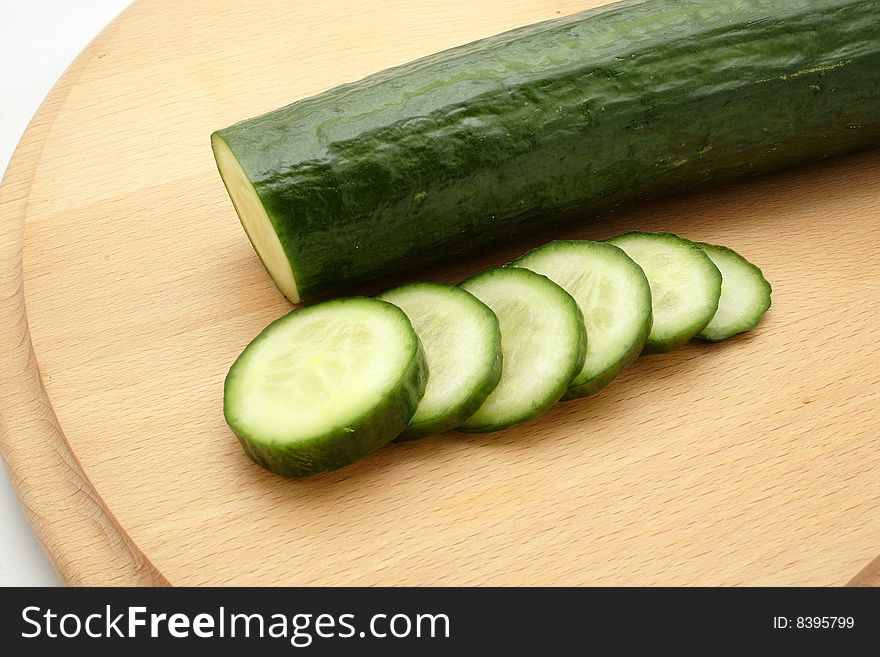 Cucumber sliced on the kitchen plank