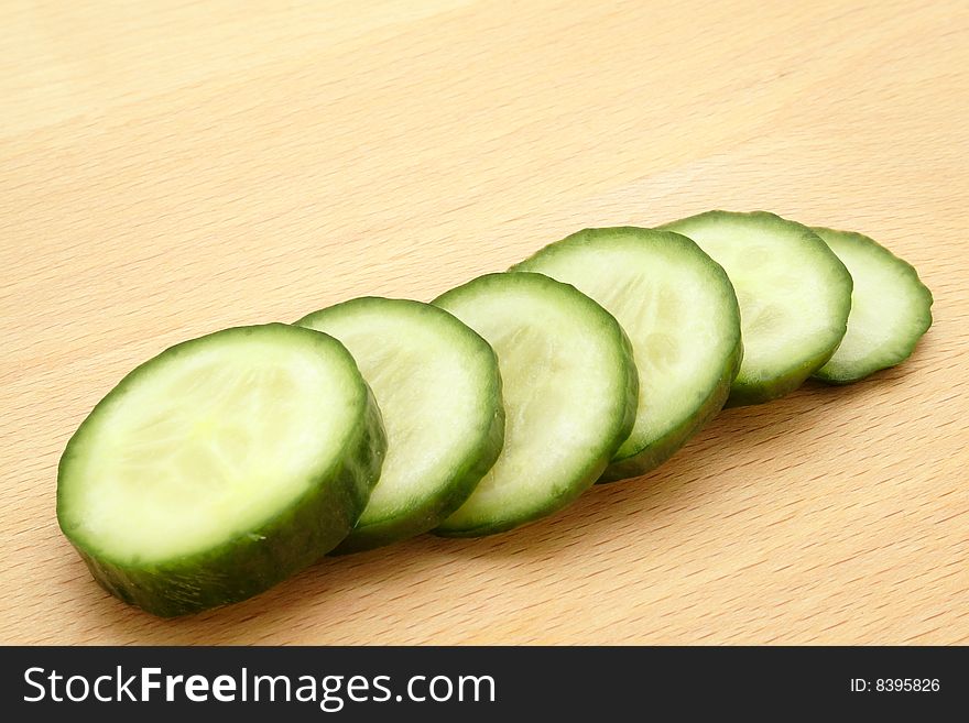 Cucumber sliced on the kitchen plank