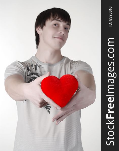 Young man with red heart isolated at white background