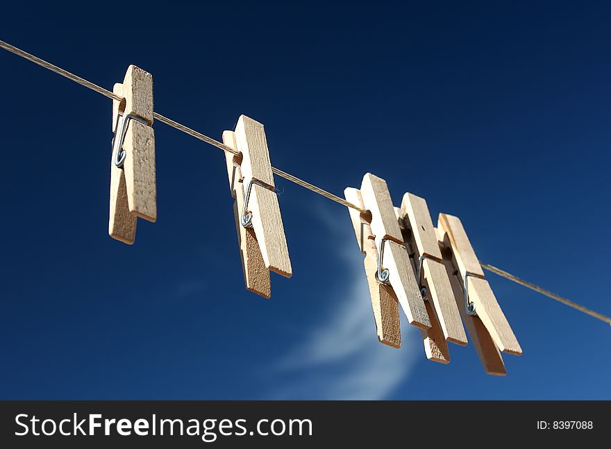 A set of five clothes pins in the blue sky