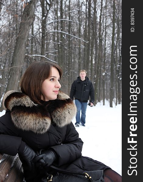 A young couple walks in the park. Winter.