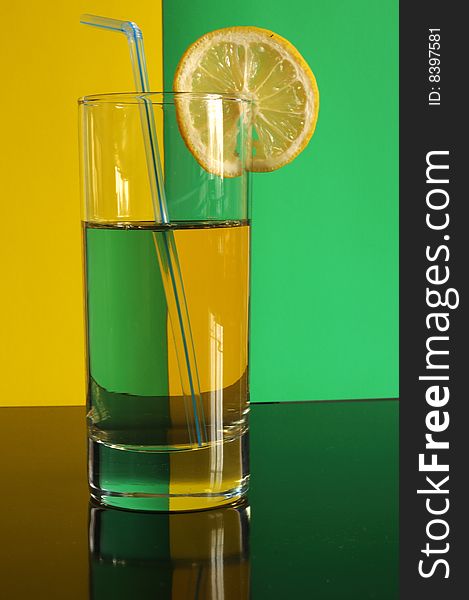 A glass of coctail with a piece of lemon and cocktail tube. A glass of coctail with a piece of lemon and cocktail tube