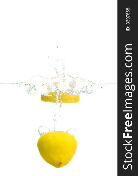 Big yellow lemon splashing in water