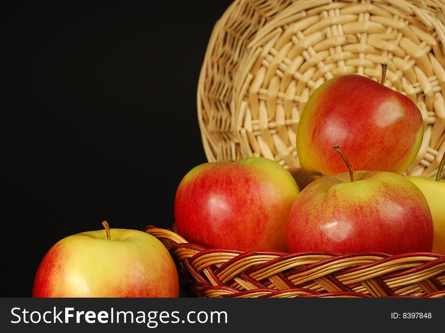 Apples in a basket on a black background