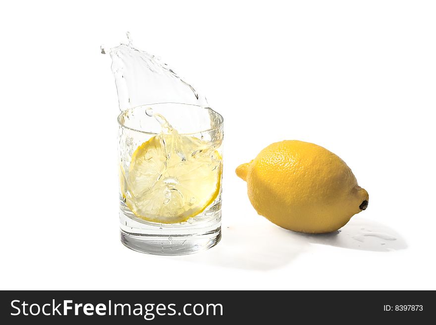 Lemon falling to glass with water. Lemon falling to glass with water