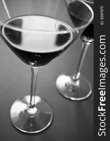 Dark drink in martini glasses in black and white. Dark drink in martini glasses in black and white