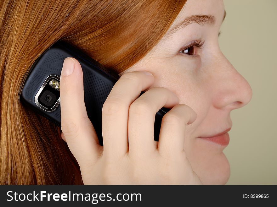 Redhead young woman speaks on the mobile phone