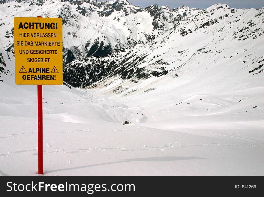Warning about leaving marked and protected piste against a mountain background. Warning about leaving marked and protected piste against a mountain background.