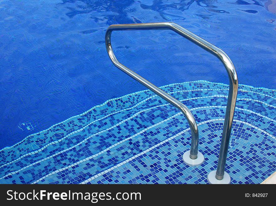 Steps on a stair to get into a pool of blue warm water. Steps on a stair to get into a pool of blue warm water.