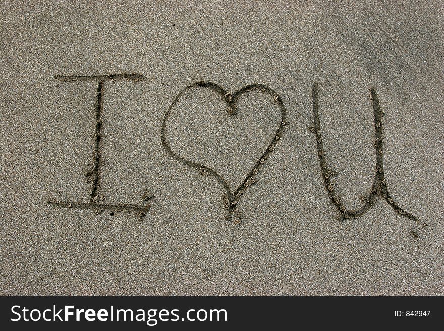 I love you written on sand with a stick. I love you written on sand with a stick
