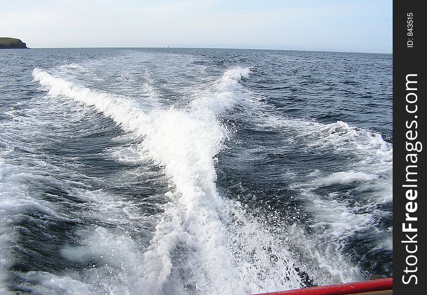 A wake and output of a powerful motor boat travelling at speed.