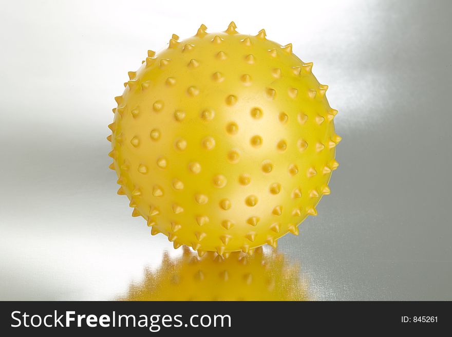 Yellow Ball on metallic surface