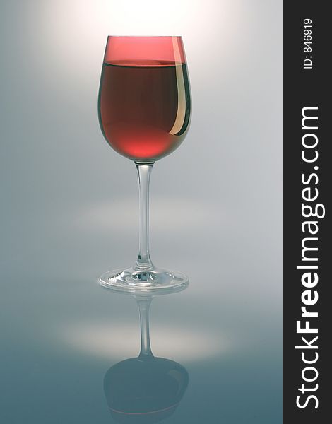 Single red wine glass and reflection