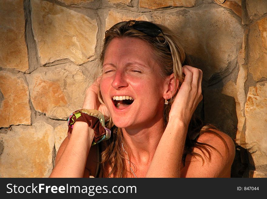 The laughing woman on a background of a wall