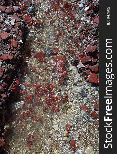 Stream with brick-red rocks