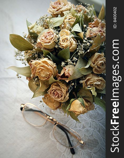 Dried roses bouquet and eyeglases