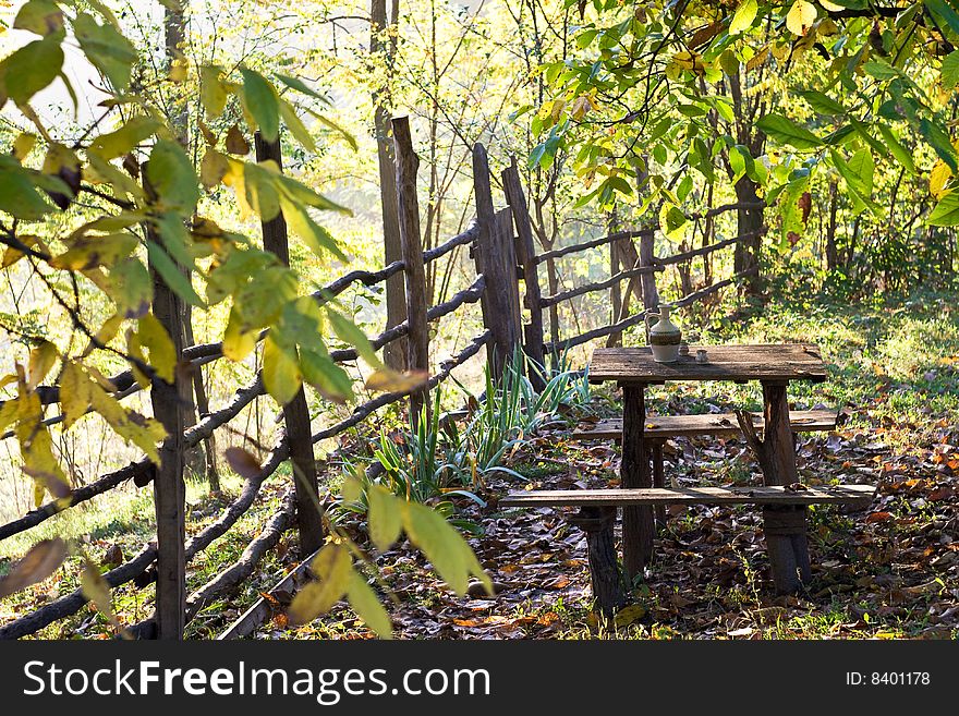 Rustic table with water pot in garden with morning sunlight