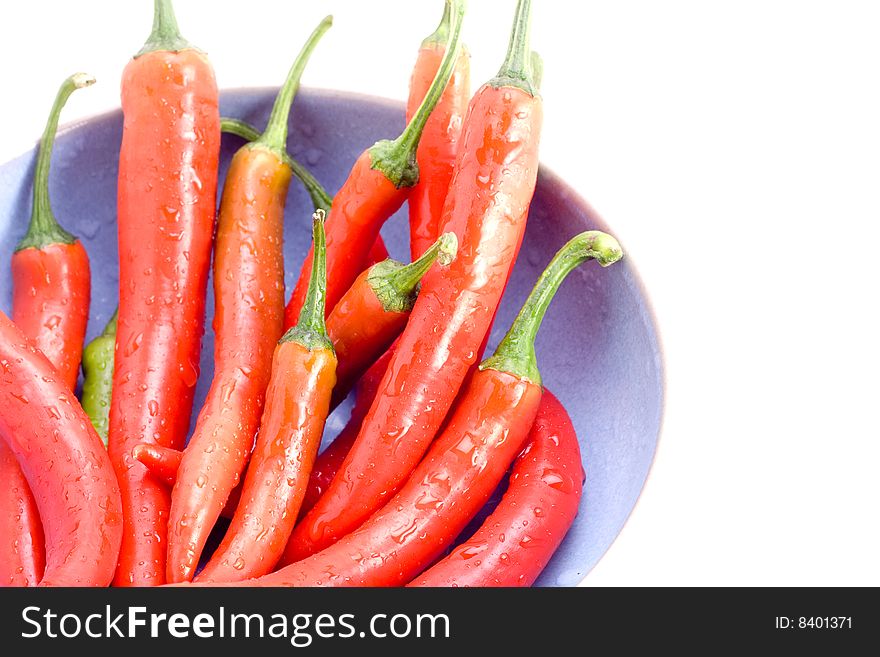Delicious and fresh red chillies in a bowl on white. Delicious and fresh red chillies in a bowl on white