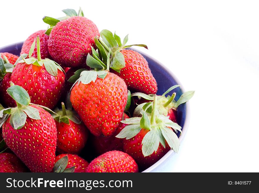 A blue bowl heaped with fresh strawberries. A blue bowl heaped with fresh strawberries