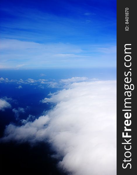 Aerial view of cloudy blue sky from aircraft window. Aerial view of cloudy blue sky from aircraft window.