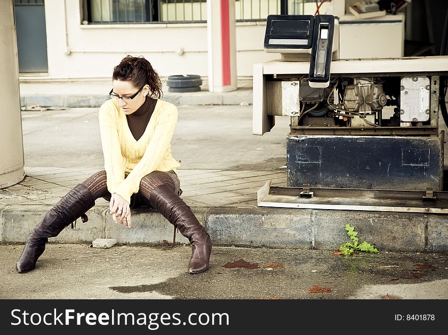 Lone young woman in abandoned fuel station. Lone young woman in abandoned fuel station.