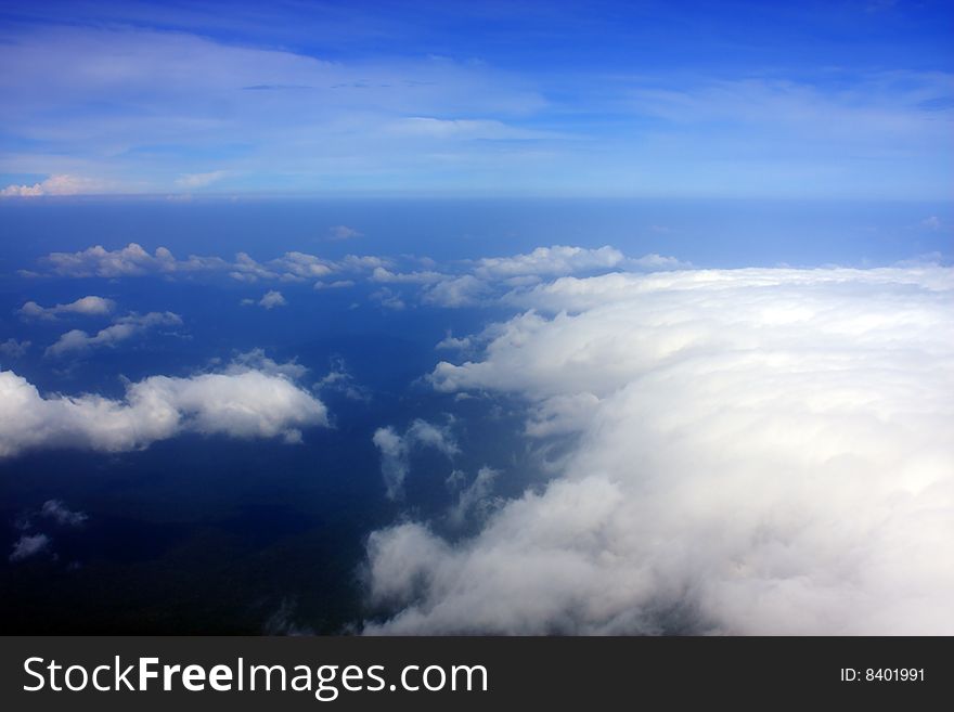 Aerial view of cloudy blue sky from aircraft window. Aerial view of cloudy blue sky from aircraft window.