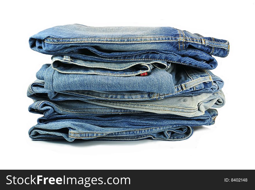 Big bunch of washed-out blue jeans isolated on white background