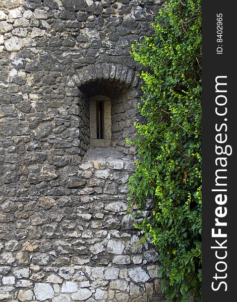 A small window set in a stone wall. A small window set in a stone wall