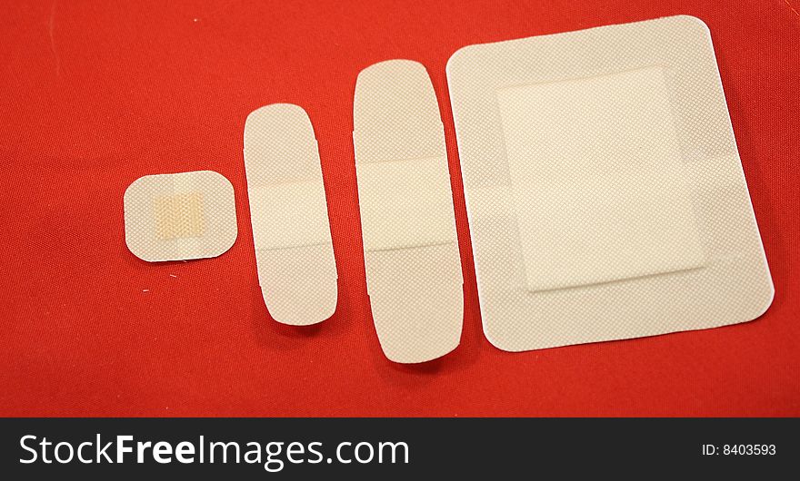 Four bandages isolated on a red background. Four bandages isolated on a red background.