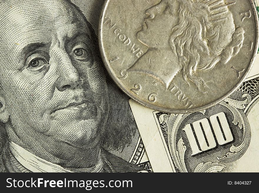 A closeup of a United States silver Peace dollar and Benjamin Franklin's face. A closeup of a United States silver Peace dollar and Benjamin Franklin's face.