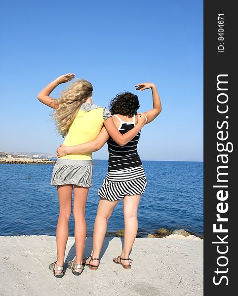 Blond and brunette girls at the sea.