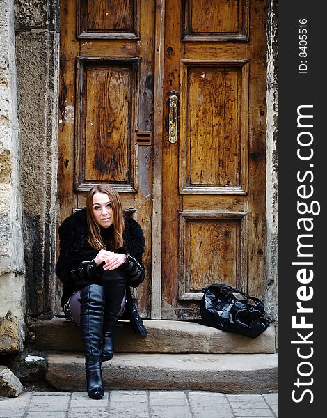 Stock photo: an image of a sad girl  sitting at the door