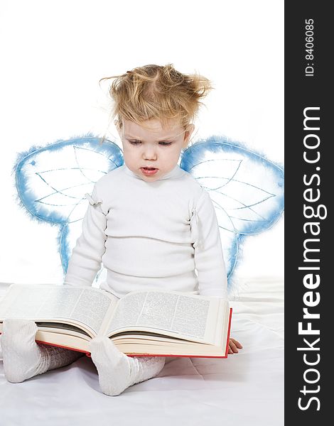 Stock photo: an image of a baby with a book and wings. Stock photo: an image of a baby with a book and wings