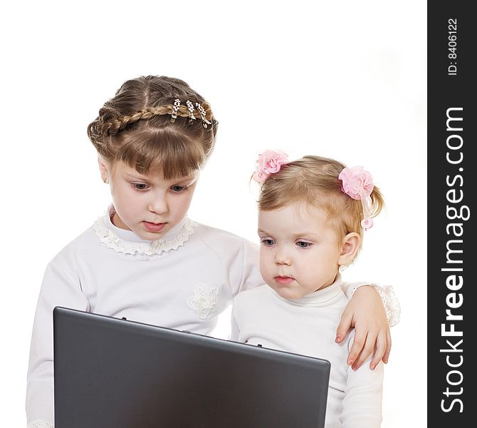 Stock photo: an image of two little girls with black laptop. Stock photo: an image of two little girls with black laptop