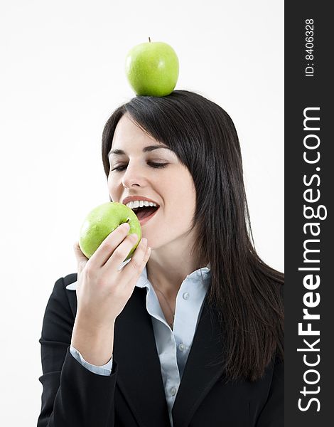 Mid adult woman with green apple on head on white background