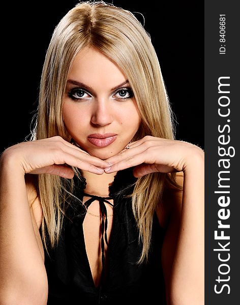 Young beautiful blond  girl on black background.
