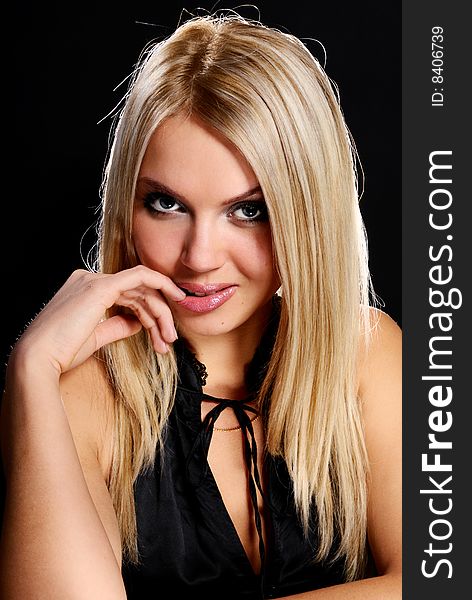Young beautiful blond  girl on black background.