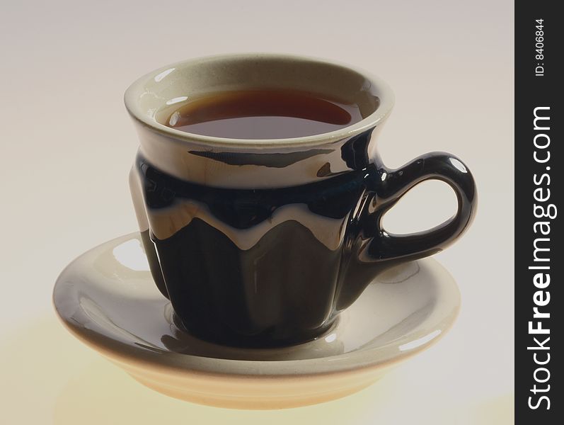 Black cup of tea isolated on a white background