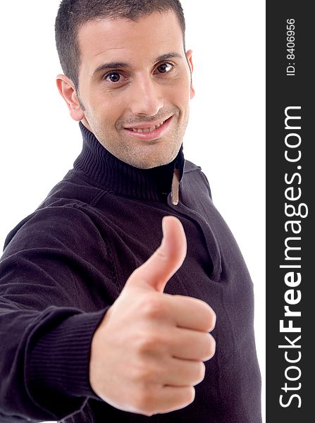 Young man showing thumbs up and looking at camera on an isolated white background