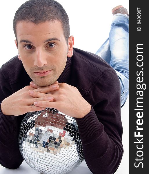 Young guy lying with disco ball on an isolated white background