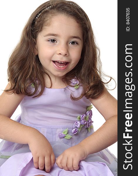 Happy girl sitting and playing in a pretty lilac purple dress decorated with fabric and gauze florals and leaves. Happy girl sitting and playing in a pretty lilac purple dress decorated with fabric and gauze florals and leaves.