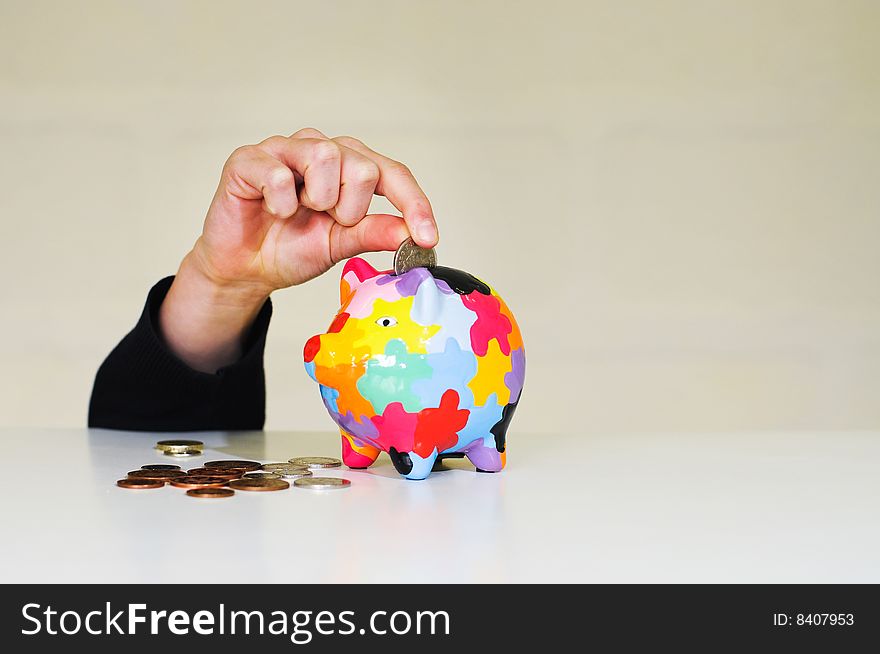 Image of hand putting money in piggybank