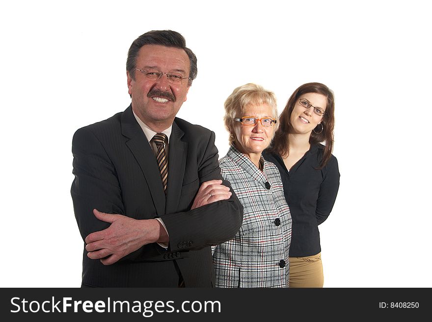 Small group of business people in business suits standing looking forward. Focus is on the mature man in front. Small group of business people in business suits standing looking forward. Focus is on the mature man in front.