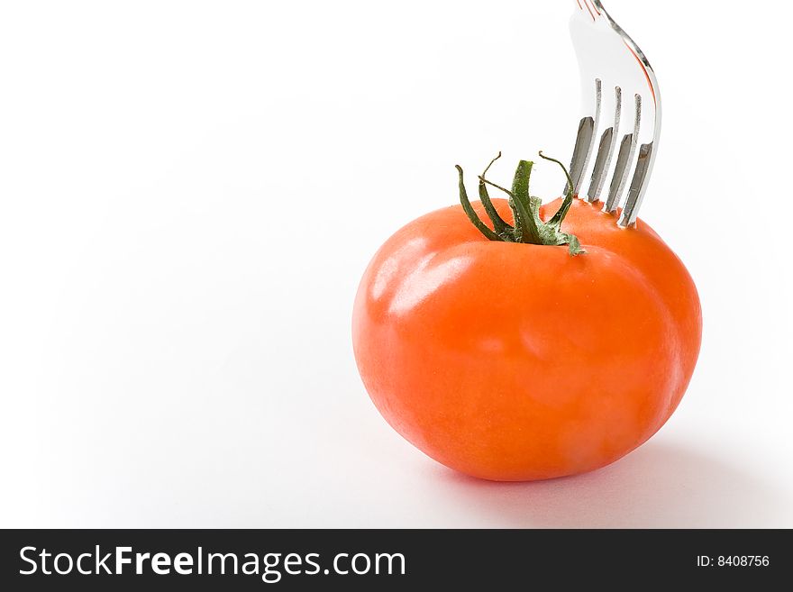 Tomato and fork on white background