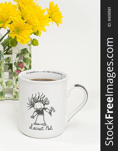 A coffee mug from a secret pal with yellow flowers in the background. A coffee mug from a secret pal with yellow flowers in the background.