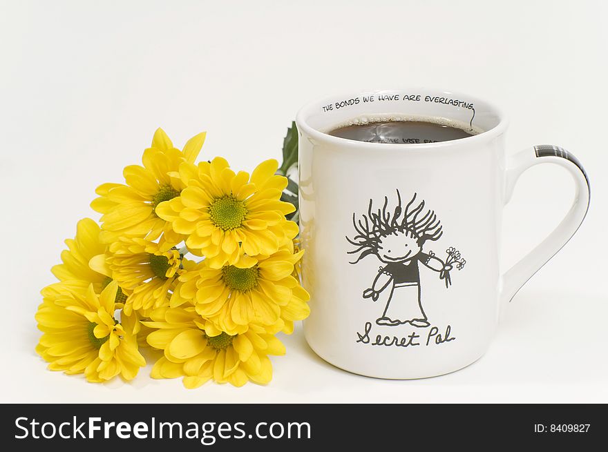 Cup of coffee with yellow flowers beside cup