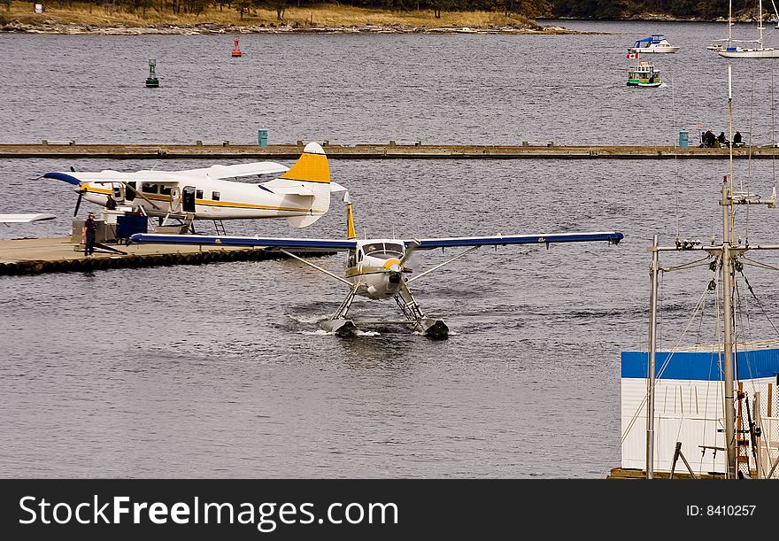 Two sea planes in a busy harbor