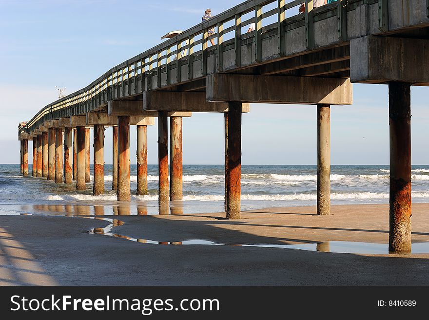 A tall pier itaken in thae late afternoon sunlight with long, deep shadows.