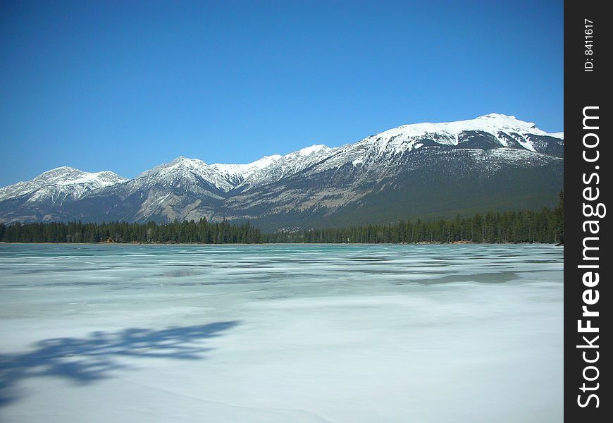 A semi frozen lake against the mountains of Jasper National Park. A semi frozen lake against the mountains of Jasper National Park