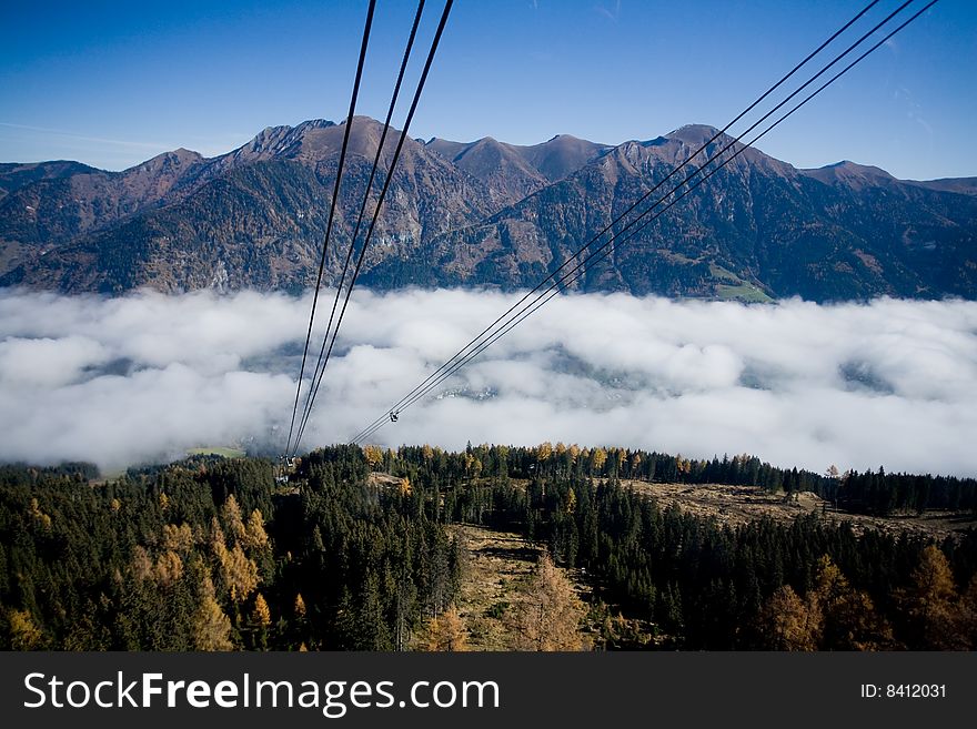 High mountain with white clouds and cable